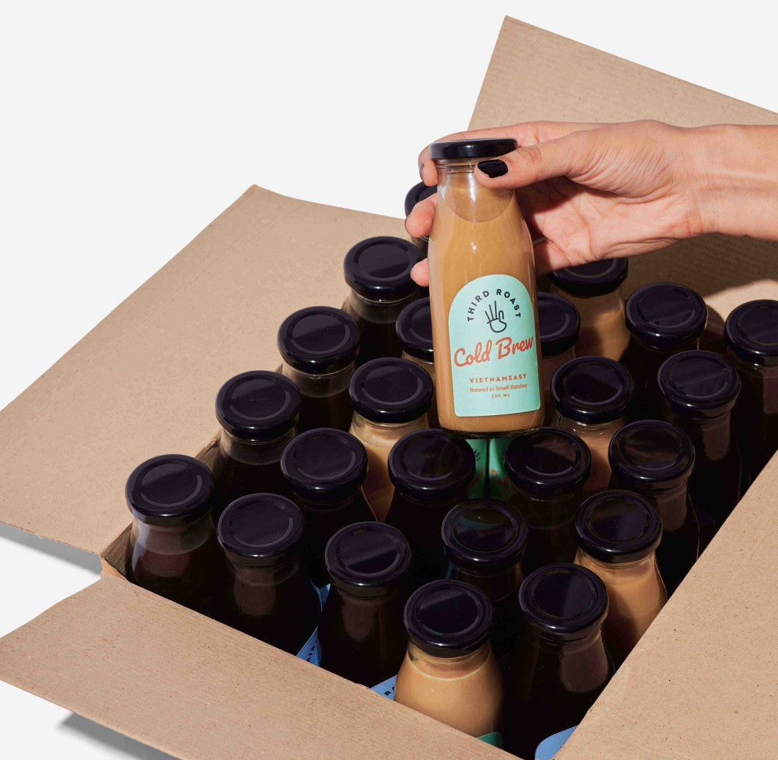 one hand pulling out a bottle of a carton