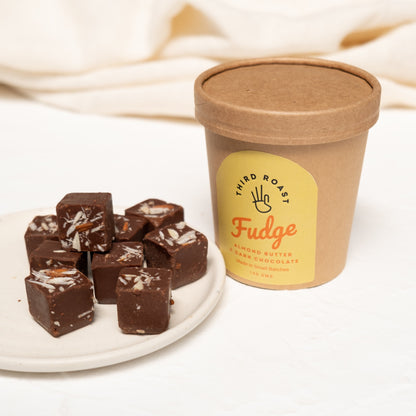 fudge pieces displayed in a ceramic plate with a brown tub container on the side